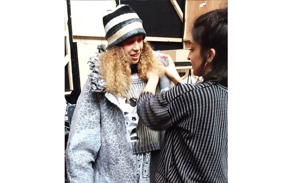 Grace making final adjustments on a model before a Central St. Martins press show